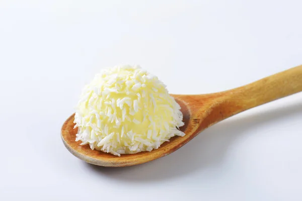 Coconut truffle on wooden spoon — Stock Photo, Image