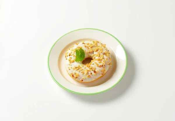 Glazed donut with nuts — Stock Photo, Image