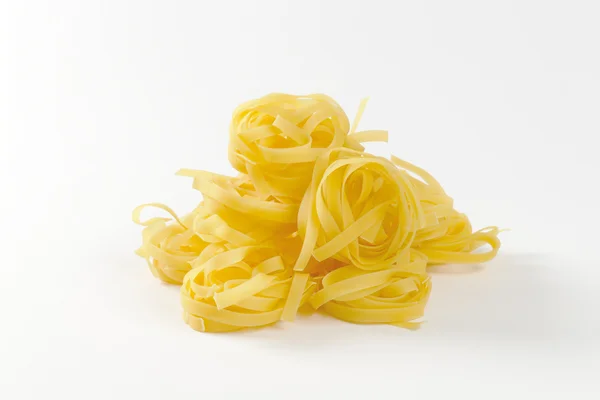 Nests of dry pasta tagliatelle — Stock Photo, Image