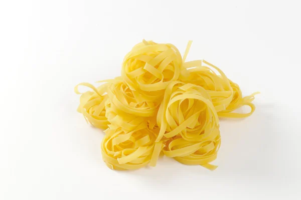 Nests of dry pasta tagliatelle — Stock Photo, Image