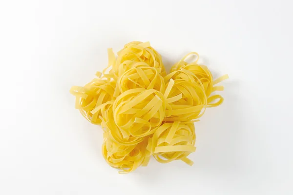 Nests of dry pasta tagliatelle — Stock Photo, Image