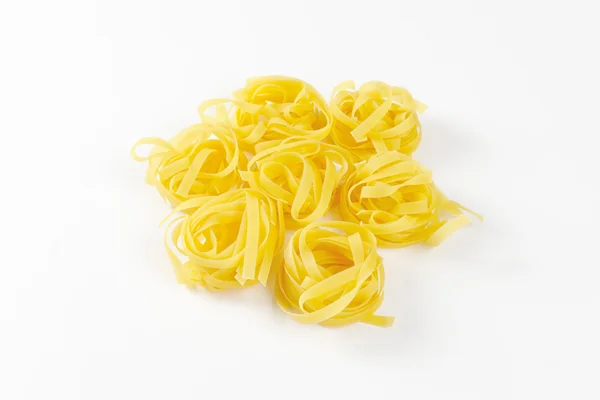 Nests of dry pasta tagliatelle — Stock Photo, Image