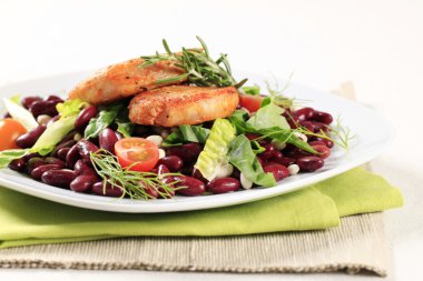 Terbiye edilmiş domuz eti ve fasulye salatası.