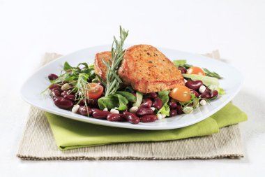 Terbiye edilmiş domuz eti ve fasulye salatası.