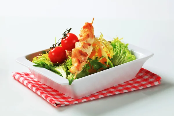 Chicken skewers and salad greens — Stock Photo, Image