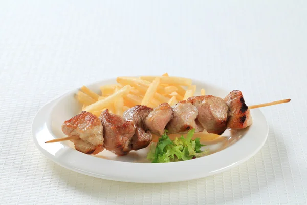 Pork skewer with French fries — Stock Photo, Image