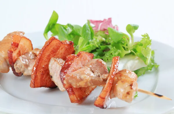 Pork skewer with salad greens — Stock Photo, Image