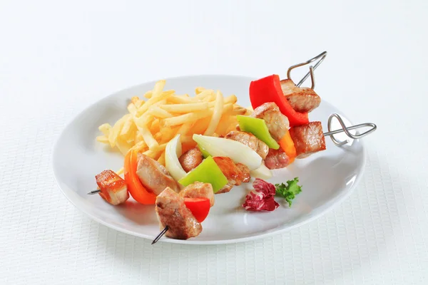 Schweinespieße mit Pommes — Stockfoto