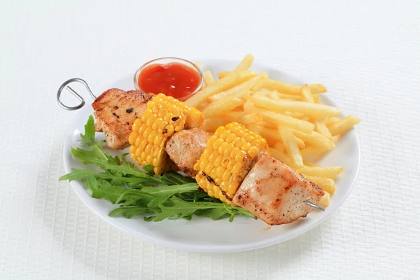 Turkey and sweetcorn skewer with French fries — Stock Photo, Image