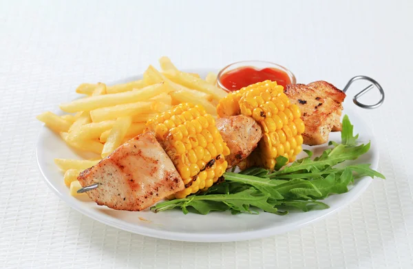 Turkey and sweetcorn skewer with French fries — Stock Photo, Image