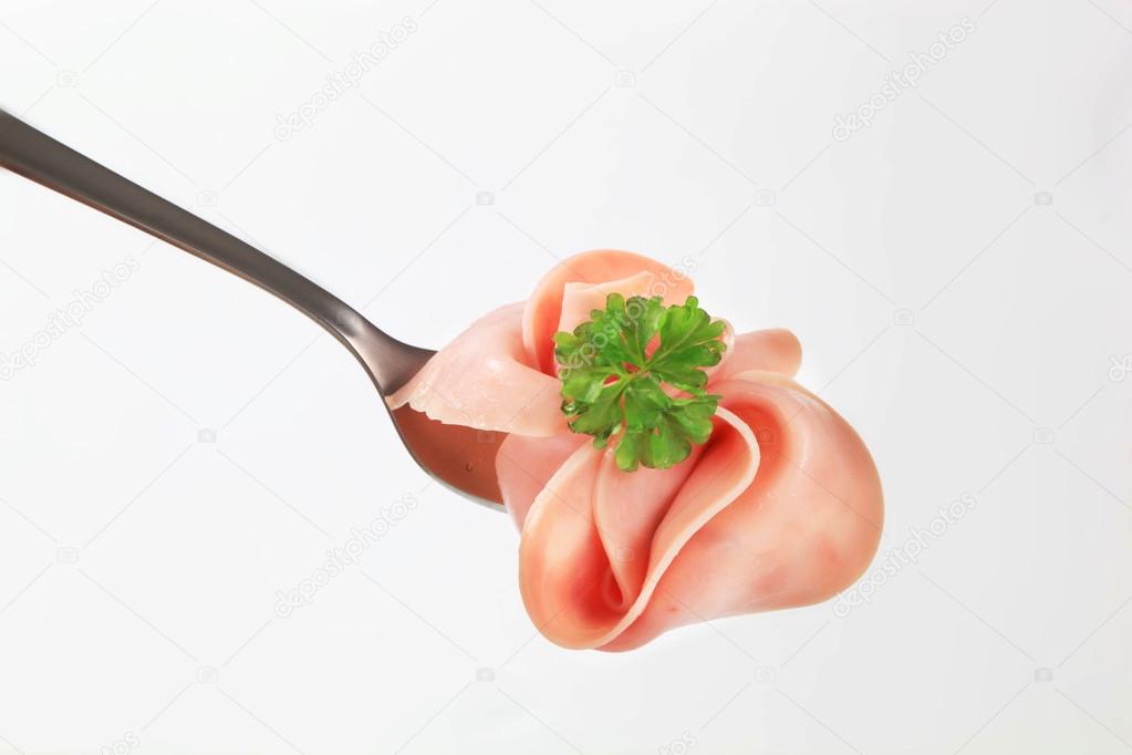 Slices of ham on fork