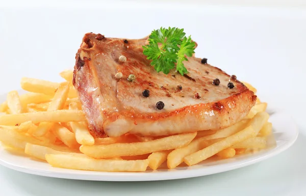 Pan fried pork chop with fries — Stock Photo, Image