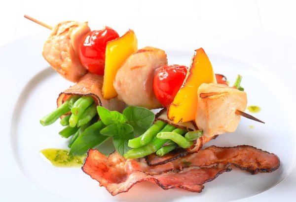 Chicken skewer and bacon-wrapped green beans — Stock Photo, Image