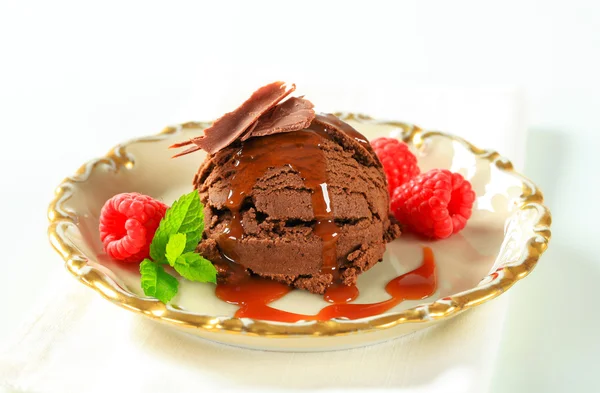 Chocolate brownie ice cream with caramel sauce and raspberries — Stock Photo, Image