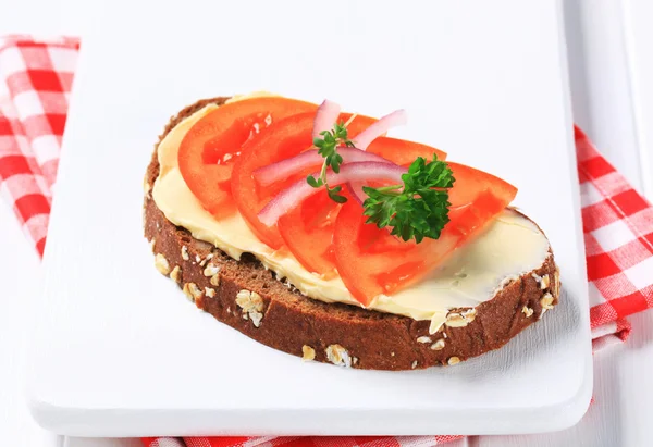 Pão integral com manteiga e tomate — Fotografia de Stock