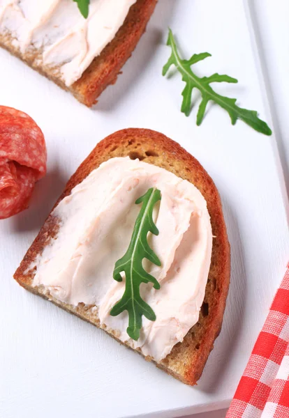 Knapperig brood met verspreiding en salami — Stockfoto
