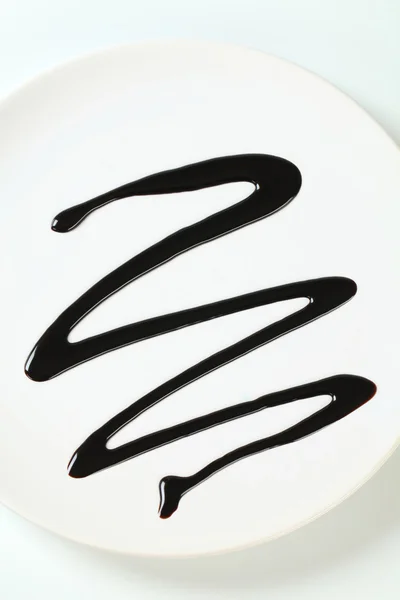 Chocolate syrup drip on plate — Stock Photo, Image