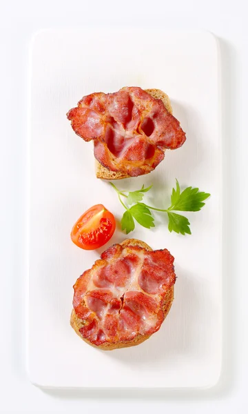 Crispy fried bacon on bread — Stock Photo, Image