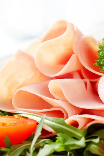 Sliced ham with arugula leaves and tomatoes — Stock Photo, Image