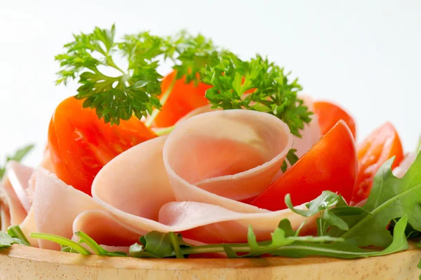 Sliced ham with arugula and tomatoes — Stock Photo, Image