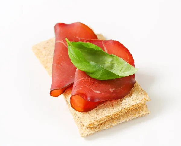 Whole grain crisp bread with smoked beef — Stock Photo, Image