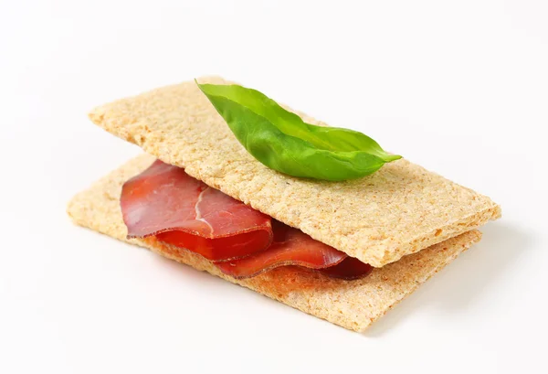 Whole grain crisp bread with smoked beef — Stock Photo, Image