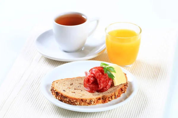 Brot mit Salami, Tee und Orangensaft — Stockfoto