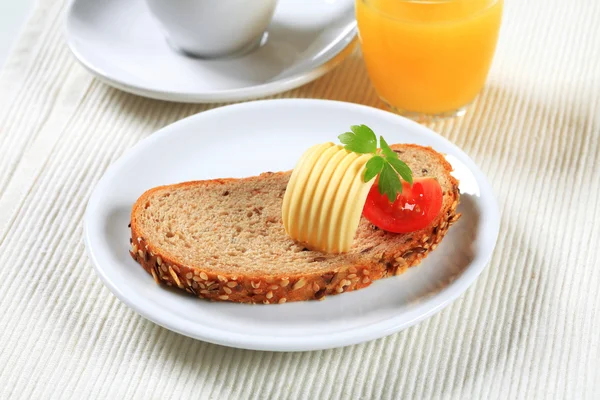 Brot mit Butter, Tee und Orangensaft — Stockfoto