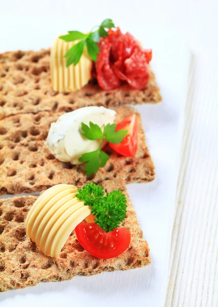 Whole grain crispbread with various toppings — Stock Photo, Image