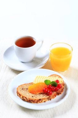 Ekmek ve tereyağı, çay ve portakal suyu