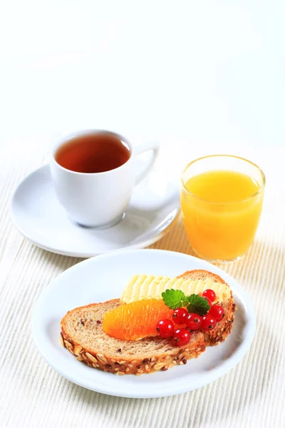 Brot und Butter, Tee und Orangensaft — Stockfoto