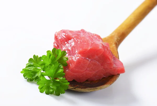 Raw beef meat on wooden spoon — Stock Photo, Image