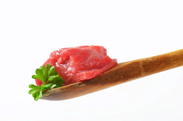 Carne de res cruda en cuchara de madera — Foto de Stock