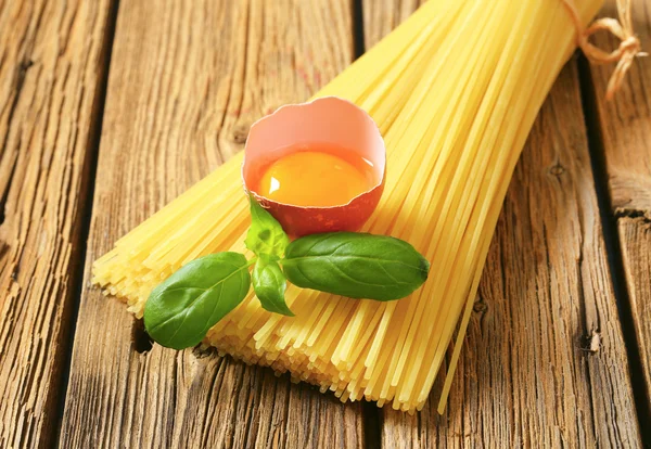 Dried spaghetti and raw egg — Stock Photo, Image