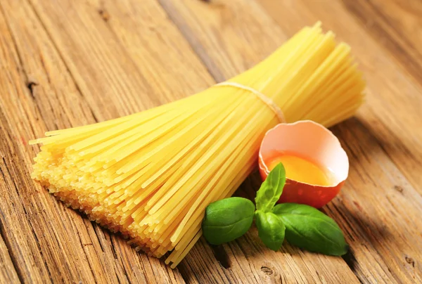 Dried spaghetti and raw egg — Stock Photo, Image