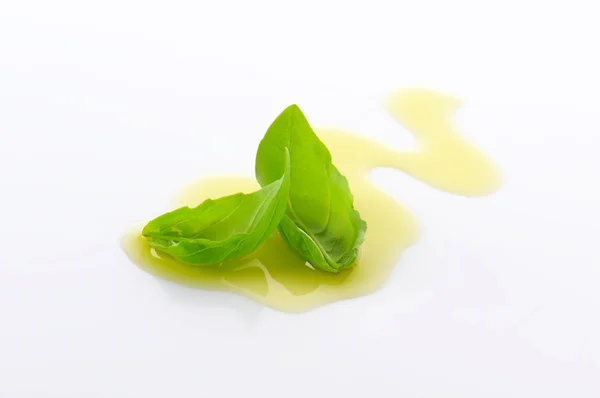 Olive oil drizzle and basil leaves — Stock Photo, Image