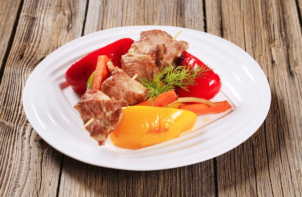 Roasted meat on skewer and vegetables — Stock Photo, Image