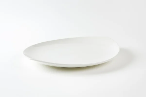 Flat oval white porcelain plate — 스톡 사진