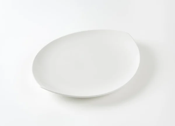 Flat oval white porcelain plate — 스톡 사진