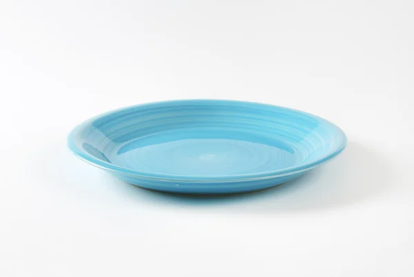 Rimless round blue ceramic plate — Stock Photo, Image