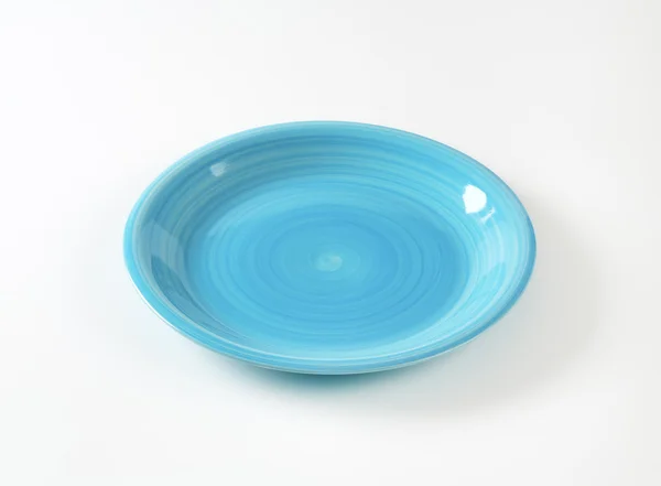 Rimless round blue ceramic plate — 图库照片
