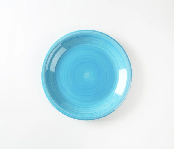 Rimless round blue ceramic plate — 图库照片
