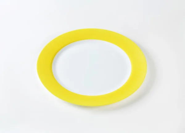 Біла тарілка з жовтим фланцем — стокове фото