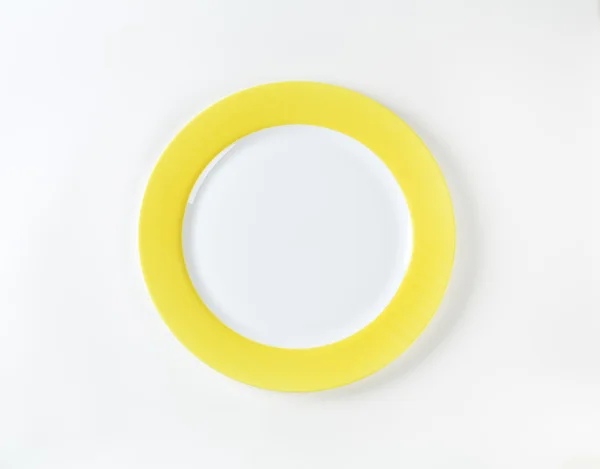 White plate with yellow rim — Zdjęcie stockowe
