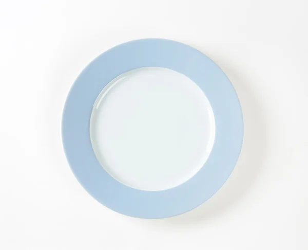 White plate with blue rim — 图库照片