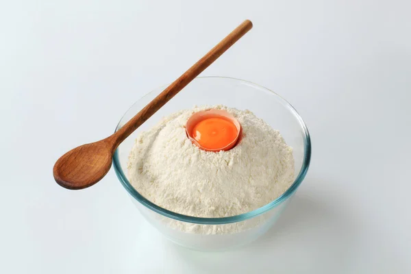 Harina blanca con huevo y cuchara de madera — Foto de Stock