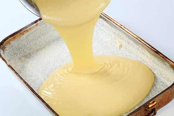 Pouring batter into baking pan — Stock Photo, Image