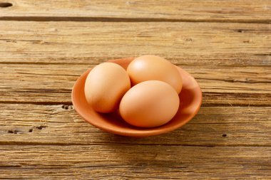 Pişmiş plaka üzerinde üç kahverengi yumurta