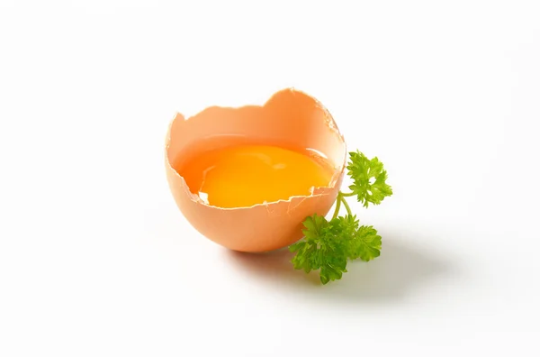 Raw egg yolk in broken shell — Stock Photo, Image