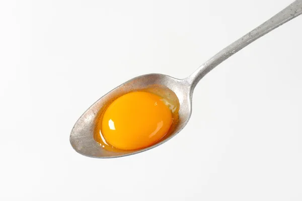 Raw egg yolk on spoon — Stock Photo, Image